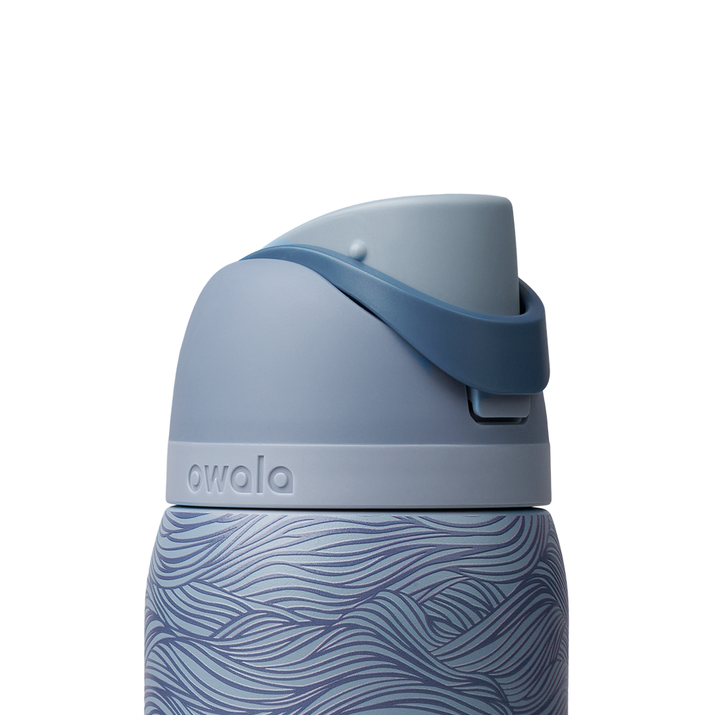 Owala FreeSip 32oz, slate blue body with embossed wave texture, lighter blue-gray lid, slate flip cap, and darker blue carry loop
